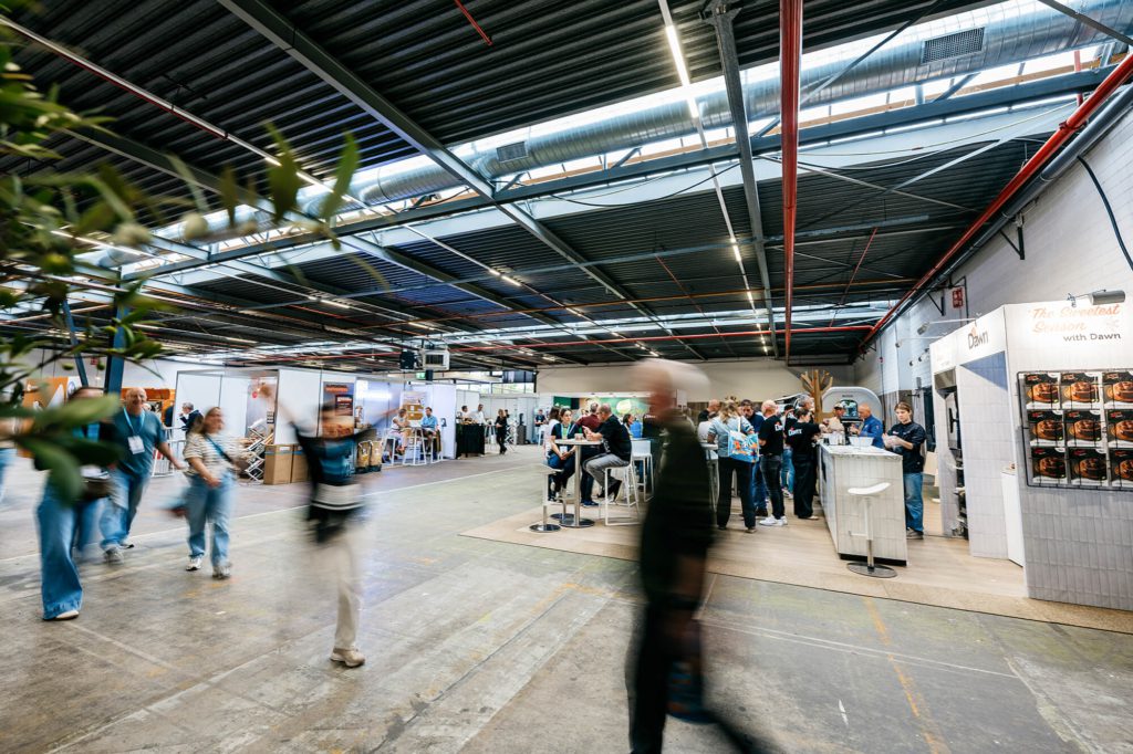 Beursvloer in de Loods met bezoekers en stands op de achtergrond