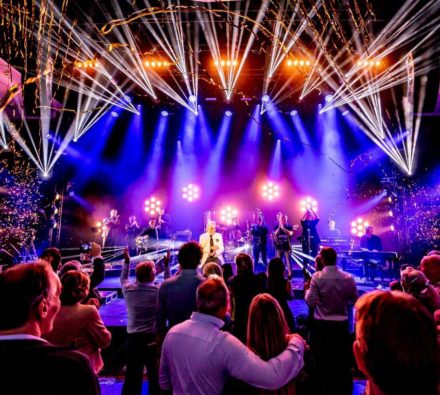 Podium met lasers en verlichting voor een groot publiek tijdens een feestavond